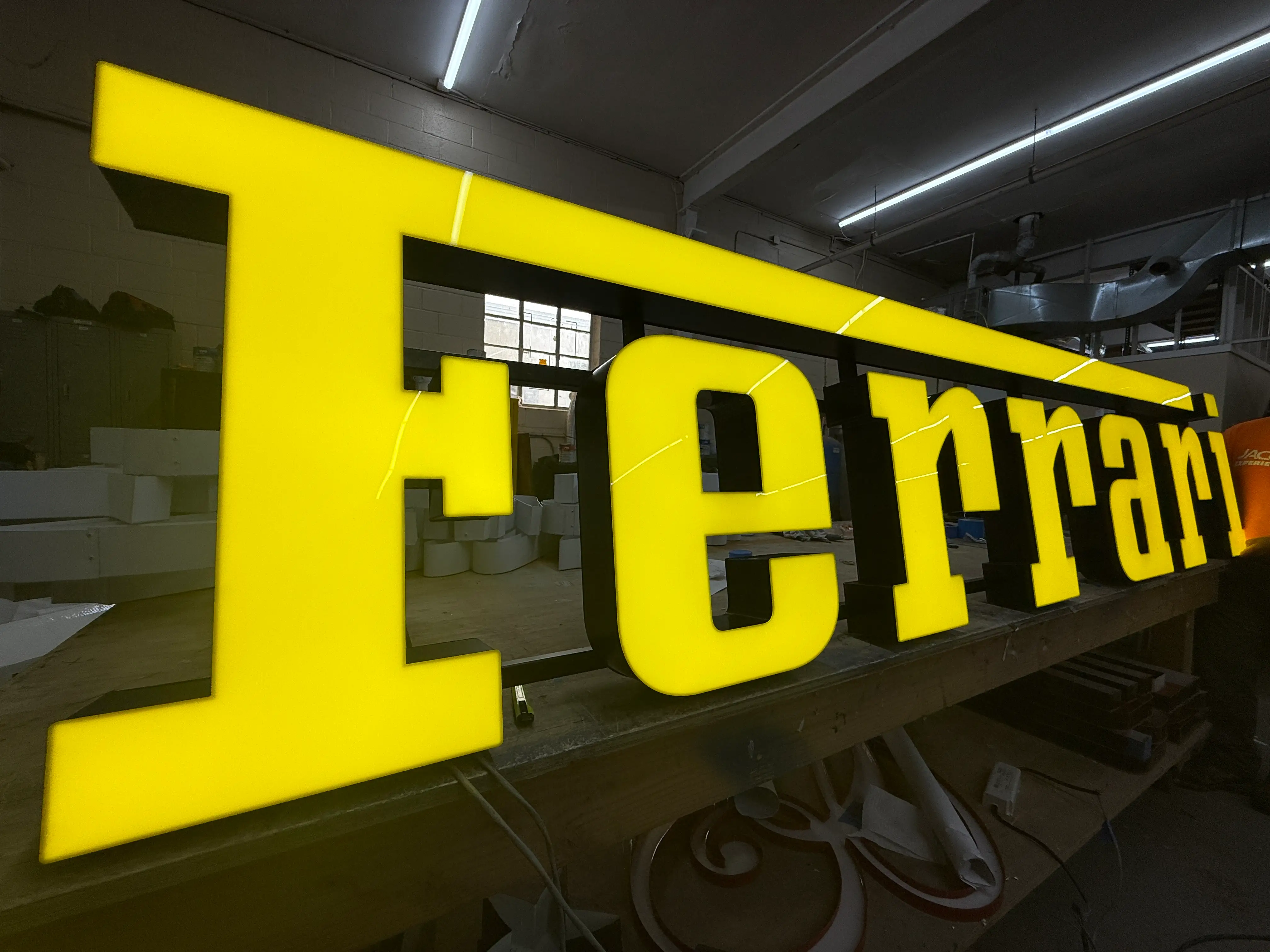 Illuminated channel letters being prepared in a sign shop.